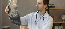 врач изучает рентгеновский снимок руки